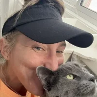 Dawn during a cat visit, kissing a grey cat
